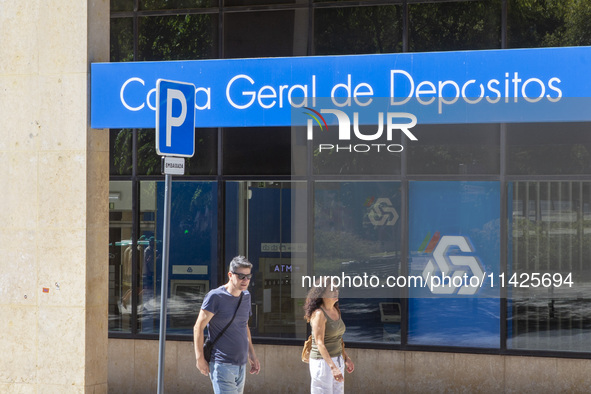 People are walking by a CGD building in Lisbon, Portugal, on July 21, 2024. An interruption of Microsoft systems, related to the cybersecuri...