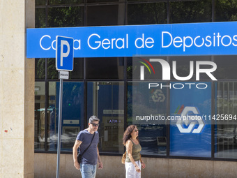 People are walking by a CGD building in Lisbon, Portugal, on July 21, 2024. An interruption of Microsoft systems, related to the cybersecuri...