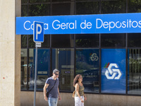 People are walking by a CGD building in Lisbon, Portugal, on July 21, 2024. An interruption of Microsoft systems, related to the cybersecuri...