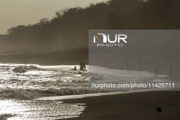 People are visiting Goa Cemara Beach, one of the tourist destinations in Bantul, Yogyakarta, Indonesia, during sunset on July 21, 2024. 