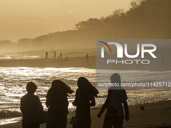 People are visiting Goa Cemara Beach, one of the tourist destinations in Bantul, Yogyakarta, Indonesia, during sunset on July 21, 2024. (