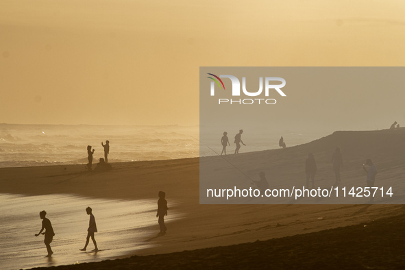 People are visiting Goa Cemara Beach, one of the tourist destinations in Bantul, Yogyakarta, Indonesia, during sunset on July 21, 2024. 