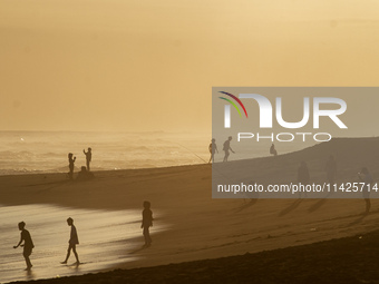 People are visiting Goa Cemara Beach, one of the tourist destinations in Bantul, Yogyakarta, Indonesia, during sunset on July 21, 2024. (