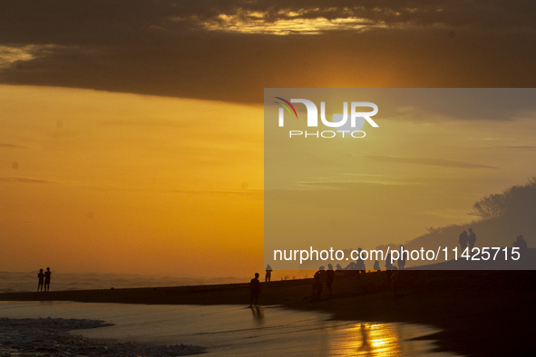 People are visiting Goa Cemara Beach, one of the tourist destinations in Bantul, Yogyakarta, Indonesia, during sunset on July 21, 2024. 