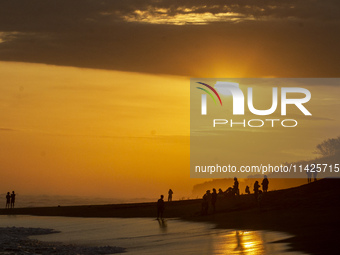 People are visiting Goa Cemara Beach, one of the tourist destinations in Bantul, Yogyakarta, Indonesia, during sunset on July 21, 2024. (