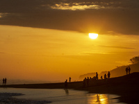 People are visiting Goa Cemara Beach, one of the tourist destinations in Bantul, Yogyakarta, Indonesia, during sunset on July 21, 2024. (