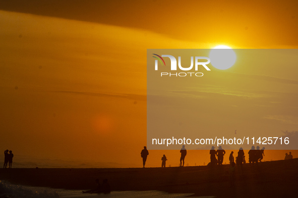 People are visiting Goa Cemara Beach, one of the tourist destinations in Bantul, Yogyakarta, Indonesia, during sunset on July 21, 2024. 