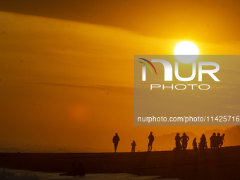 People are visiting Goa Cemara Beach, one of the tourist destinations in Bantul, Yogyakarta, Indonesia, during sunset on July 21, 2024. (