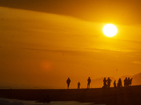 People are visiting Goa Cemara Beach, one of the tourist destinations in Bantul, Yogyakarta, Indonesia, during sunset on July 21, 2024. (