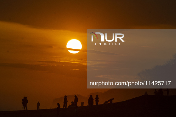 People are visiting Goa Cemara Beach, one of the tourist destinations in Bantul, Yogyakarta, Indonesia, during sunset on July 21, 2024. 