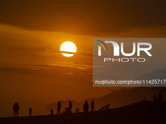 People are visiting Goa Cemara Beach, one of the tourist destinations in Bantul, Yogyakarta, Indonesia, during sunset on July 21, 2024. (