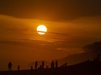 People are visiting Goa Cemara Beach, one of the tourist destinations in Bantul, Yogyakarta, Indonesia, during sunset on July 21, 2024. (