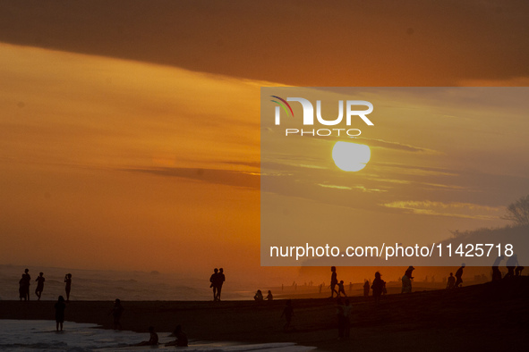 People are visiting Goa Cemara Beach, one of the tourist destinations in Bantul, Yogyakarta, Indonesia, during sunset on July 21, 2024. 