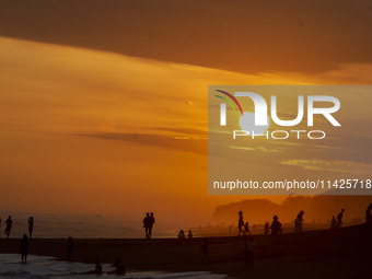 People are visiting Goa Cemara Beach, one of the tourist destinations in Bantul, Yogyakarta, Indonesia, during sunset on July 21, 2024. (