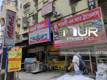 People are passing next to an International Bus transport office in Kolkata, India, on July 21, 2024. International Bus Service is stopping...