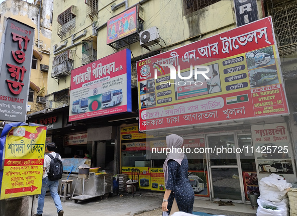 People are passing next to an International Bus transport office in Kolkata, India, on July 21, 2024. International Bus Service is stopping...