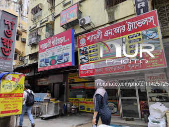 People are passing next to an International Bus transport office in Kolkata, India, on July 21, 2024. International Bus Service is stopping...