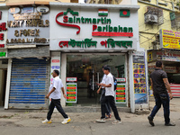 People are passing next to an International Bus transport office in Kolkata, India, on July 21, 2024. The International Bus Service is stopp...