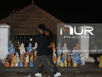 People are walking past clay idols of Lord Krishna being sold along the roadside just outside the historic Sree Padmanabhaswamy Temple durin...