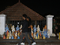 People are walking past clay idols of Lord Krishna being sold along the roadside just outside the historic Sree Padmanabhaswamy Temple durin...