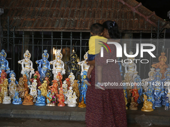 People are looking at clay idols of Lord Krishna being sold along the roadside just outside the historic Sree Padmanabhaswamy Temple during...