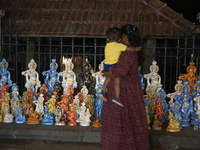 People are looking at clay idols of Lord Krishna being sold along the roadside just outside the historic Sree Padmanabhaswamy Temple during...