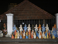 A girl is selling clay idols of Lord Krishna along the roadside just outside the historic Sree Padmanabhaswamy Temple during the night of th...