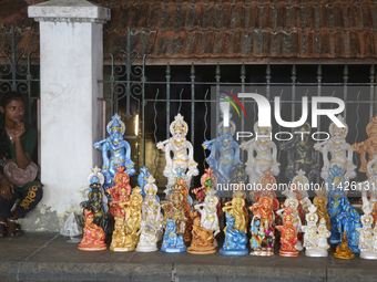 A girl is selling clay idols of Lord Krishna along the roadside just outside the historic Sree Padmanabhaswamy Temple during the night of th...