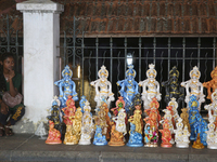 A girl is selling clay idols of Lord Krishna along the roadside just outside the historic Sree Padmanabhaswamy Temple during the night of th...