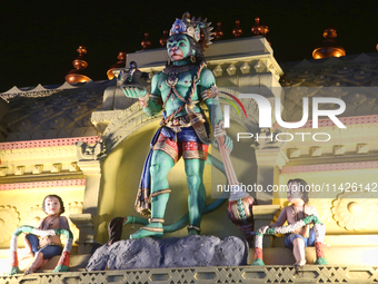 The statue of Hanuman atop the Sree Hanuman Swamy Temple is being seen during the night of the Vishu Festival in Thiruvananthapuram (Trivand...