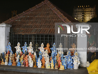 A girl is selling clay idols of Lord Krishna along the roadside just outside the historic Sree Padmanabhaswamy Temple during the night of th...