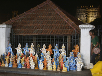 A girl is selling clay idols of Lord Krishna along the roadside just outside the historic Sree Padmanabhaswamy Temple during the night of th...