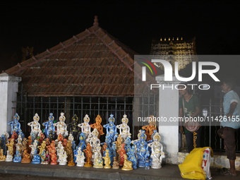 A girl is selling clay idols of Lord Krishna along the roadside just outside the historic Sree Padmanabhaswamy Temple during the night of th...