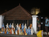 A girl is selling clay idols of Lord Krishna along the roadside just outside the historic Sree Padmanabhaswamy Temple during the night of th...