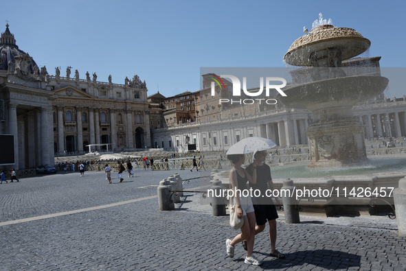 Tourists are filling up water bottles from a public fountain in Saint Peter, Rome, Italy, on July 21, 2024. 