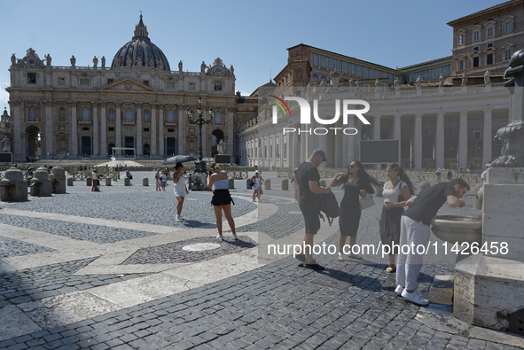 Tourists are filling up water bottles from a public fountain in Saint Peter, Rome, Italy, on July 21, 2024. 