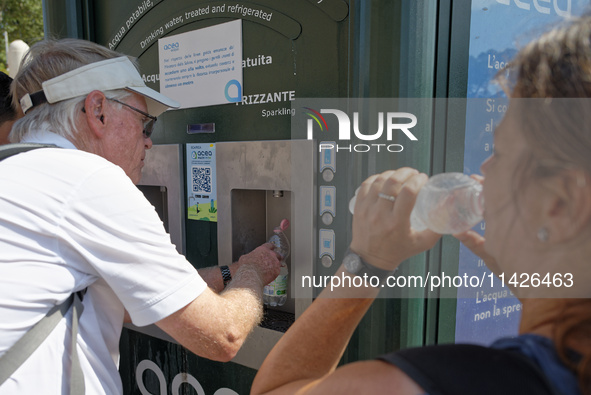 Tourists are queuing to get water from a free water dispenser in front of the Colosseum in Rome, Italy, on July 21, 2024. 