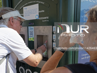 Tourists are queuing to get water from a free water dispenser in front of the Colosseum in Rome, Italy, on July 21, 2024. (