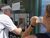 Tourists are queuing to get water from a free water dispenser in front of the Colosseum in Rome, Italy, on July 21, 2024. (