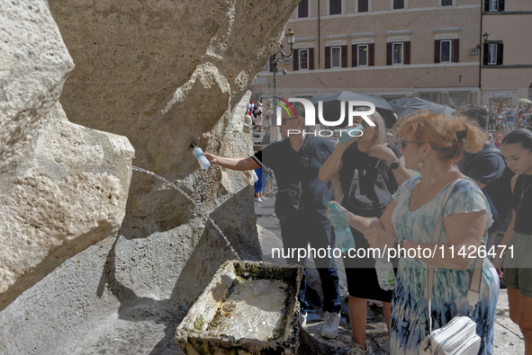 Tourists are trying to cool off with the help of fountains in the streets in Rome, Italy, on July 21, 2024, as the city is on alert for extr...