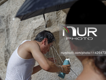 Tourists are trying to cool off with the help of fountains in the streets in Rome, Italy, on July 21, 2024, as the city is on alert for extr...