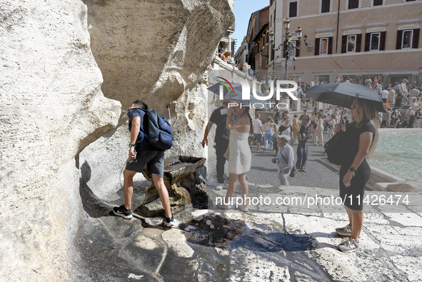 Tourists are trying to cool off with the help of fountains in the streets in Rome, Italy, on July 21, 2024, as the city is on alert for extr...