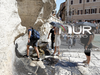 Tourists are trying to cool off with the help of fountains in the streets in Rome, Italy, on July 21, 2024, as the city is on alert for extr...