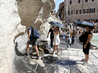 Tourists are trying to cool off with the help of fountains in the streets in Rome, Italy, on July 21, 2024, as the city is on alert for extr...