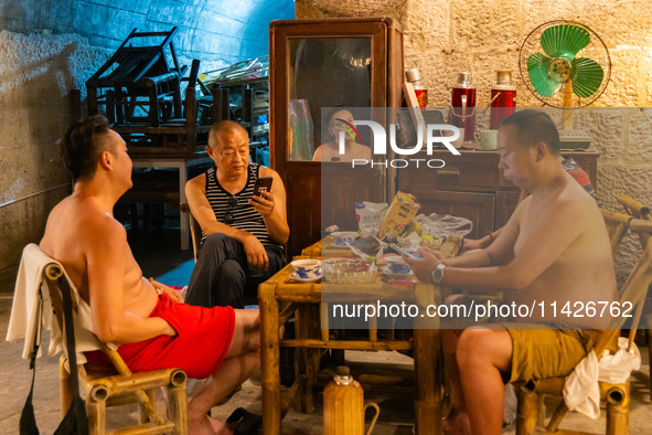 Residents are drinking tea at an old teahouse in a bomb shelter as the high temperature continues in Chongqing, China, on July 21, 2024. 