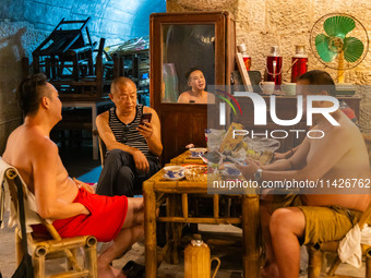 Residents are drinking tea at an old teahouse in a bomb shelter as the high temperature continues in Chongqing, China, on July 21, 2024. (