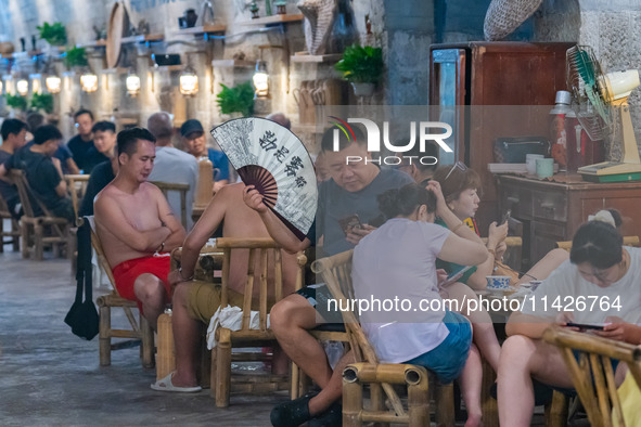 Residents are drinking tea at an old teahouse in a bomb shelter as the high temperature continues in Chongqing, China, on July 21, 2024. 