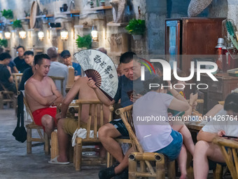 Residents are drinking tea at an old teahouse in a bomb shelter as the high temperature continues in Chongqing, China, on July 21, 2024. (