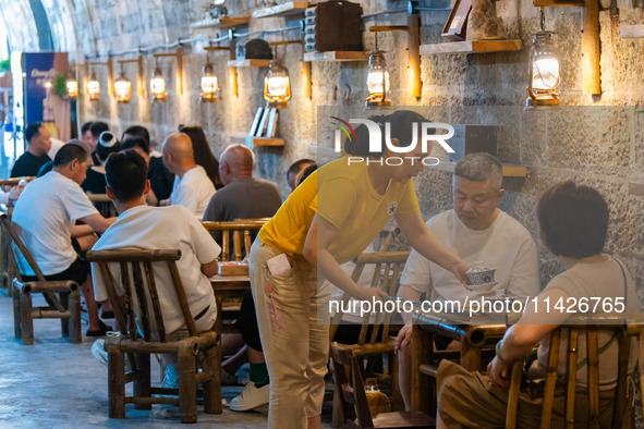 Residents are drinking tea at an old teahouse in a bomb shelter as the high temperature continues in Chongqing, China, on July 21, 2024. 