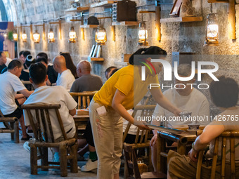 Residents are drinking tea at an old teahouse in a bomb shelter as the high temperature continues in Chongqing, China, on July 21, 2024. (